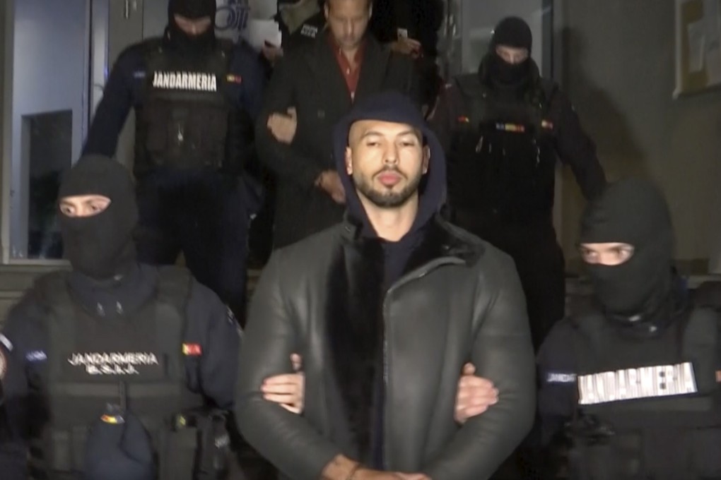 Divisive social Media personality Andrew Tate is led away by police in Romania on Thursday. Photo: Observator Antena 1 via AP