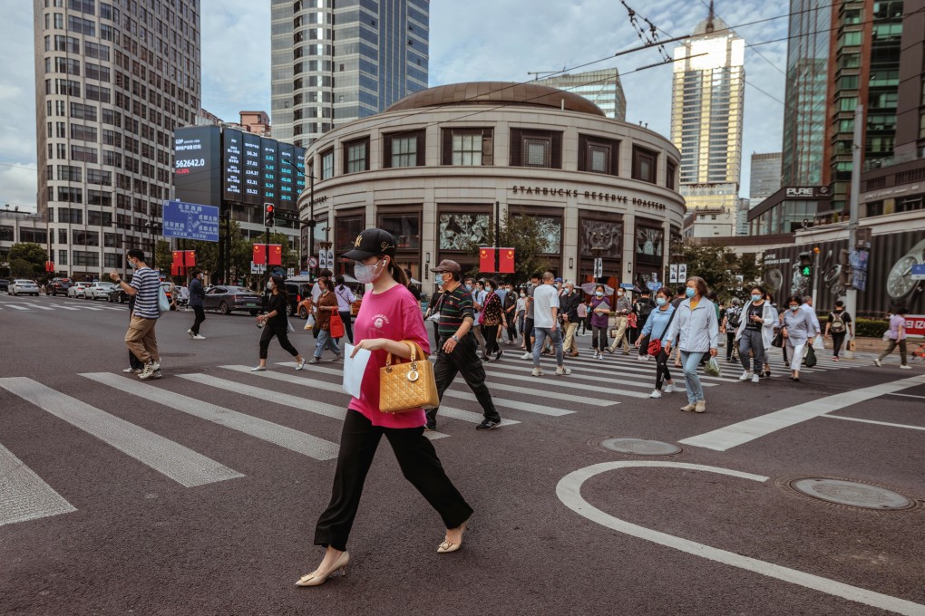People walk next to the large screen showing the latest stock and currency exchange data in Shanghai on September 29 last year. Photo: EPA-EFE