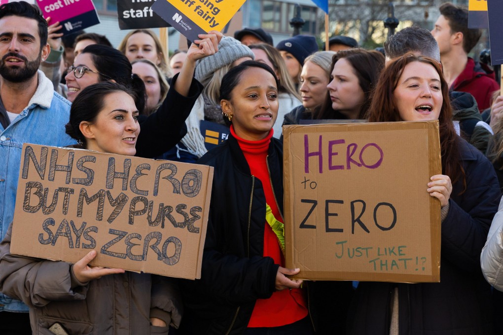 Nurses hold placards outside St Thomas’ Hospital in London, England. Recent strikes by nurses have called for a 19 per cent rise in pay. Photo: Getty Images