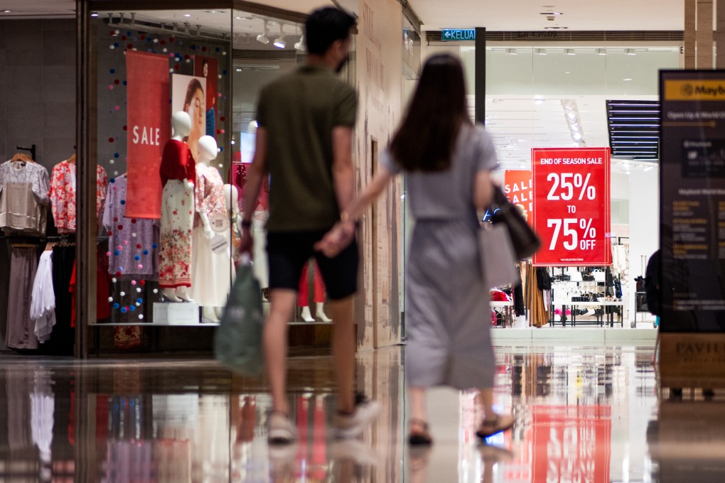 People walk outside a shop at a shopping mall in Kuala Lumpur. Malaysians are up in arms over the expansion of the sales tax in April to include low-cost items easily plucked from the internet. Photo: Xinhua