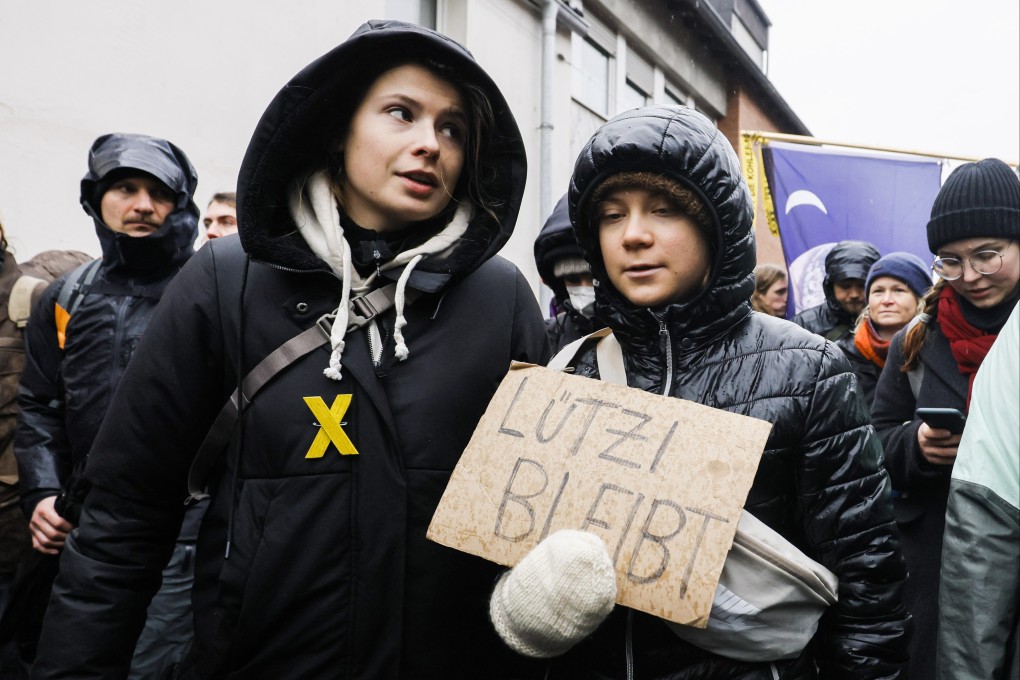 Swedish climate activist Greta Thunberg (right) holding a placard reading “Luetzi stays” is joined by  German climate activist Luisa Neubauer (left) as they attend a rally of climate protection activists near the village of Luetzerath in Germany on January 14, 2023. Photo: EPA-EFE