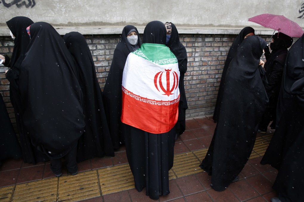 A woman wears the Iranian national flag during a protest outside the French embassy in Tehran, Iran on January 11, 2023. Photo: EPA-EFE
