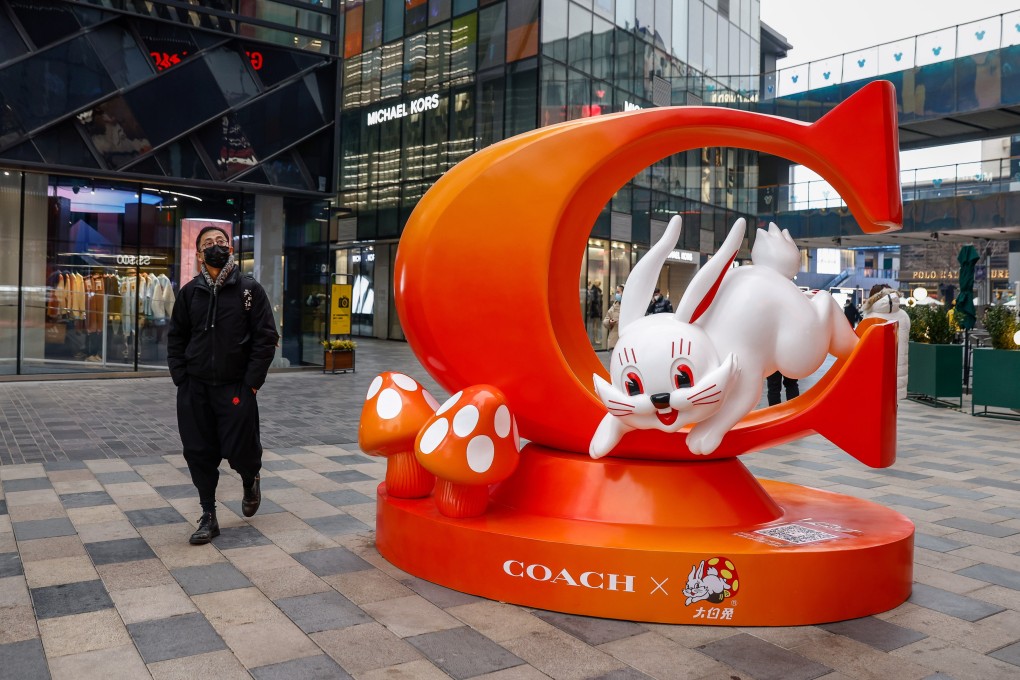 A man walks past a Lunar New Year decoration in Beijing on January 12. China’s reopening has provided a positive shock to the global economy. Photo: EPA-EFE
