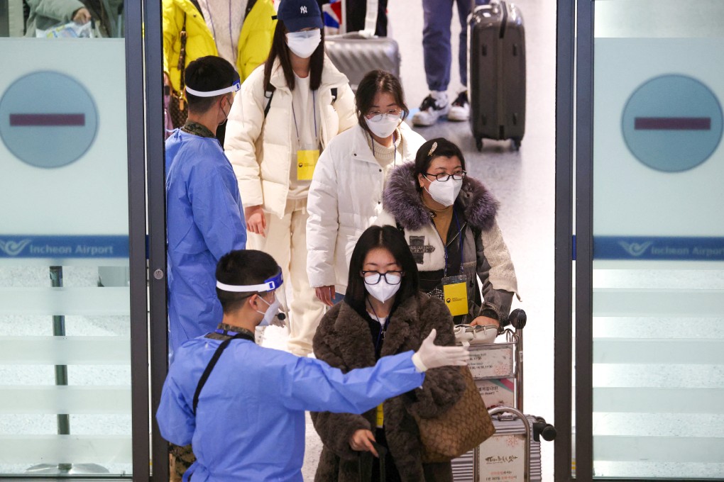 A soldier wearing personal protective equipment directs a group of Chinese tourists to a Covid-19 testing centre after their arrival at Incheon International Airport in South Korea on January 4. Photo: Reuters