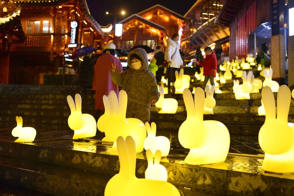 A child poses for a photo among rabbit-shaped lanterns at Xuan’en County in central Hubei province on January 15. Photo: Xinhua