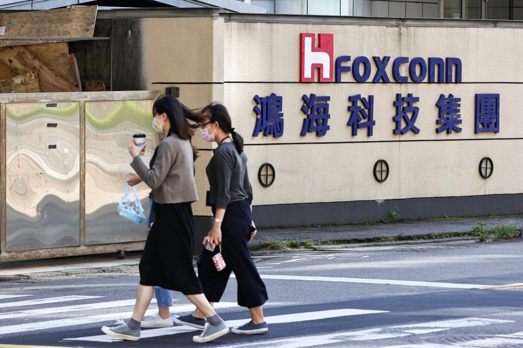 People walk past the logo of Foxconn outside the company’s building in Taipei, Taiwan. Photo: Reuters