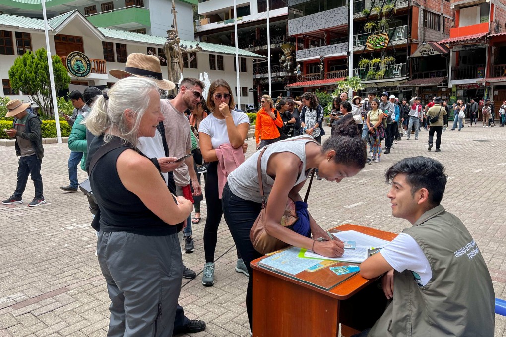 Tourists queue to sign a petition to the rail company to be evacuated on a “humanitary train” in Machu Picchu, Peru on Friday. Photo: AFP