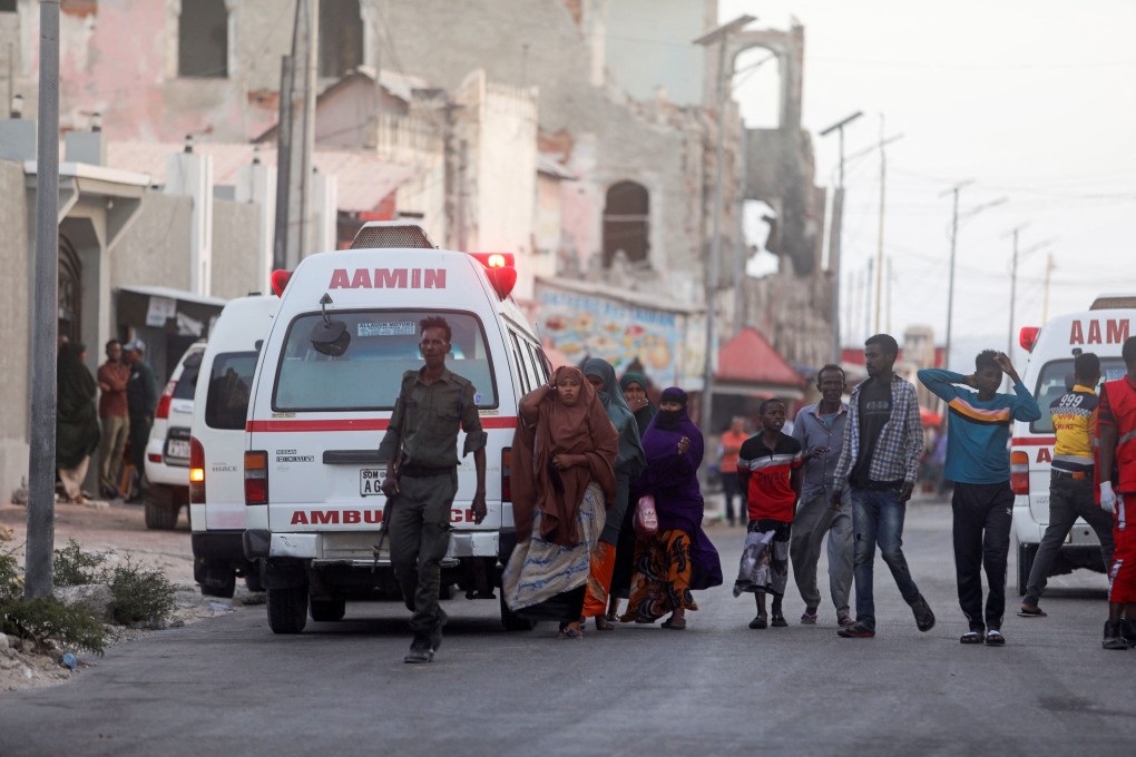Somali security forces and civilians walk to view the bodies of suspected al-Shabab fighters killed in a clash with security members at the mayor’s office in Mogadishu, Somalia on Sunday. Photo: Reuters .