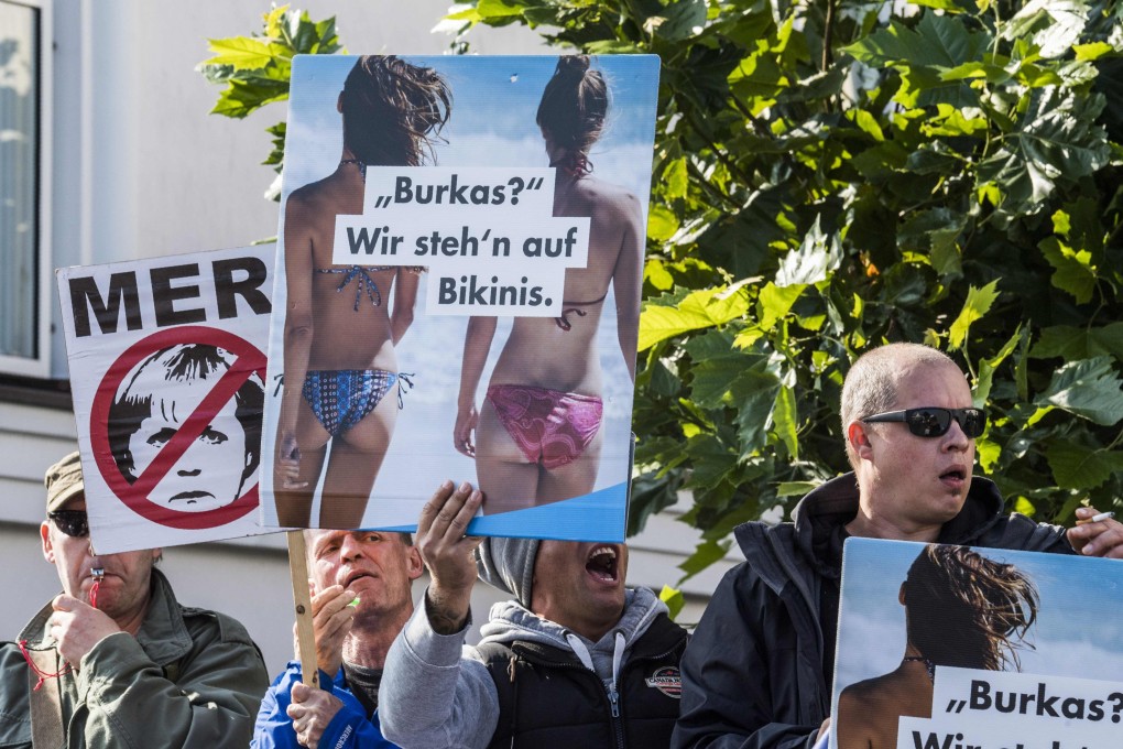 Members of the far-right, anti-immigrant Alternative for Germany display placards during a protest in Binz on September 16, 2017. The main placard reads: “Burkas? We prefer prefer bikinis.” Photo: AFP