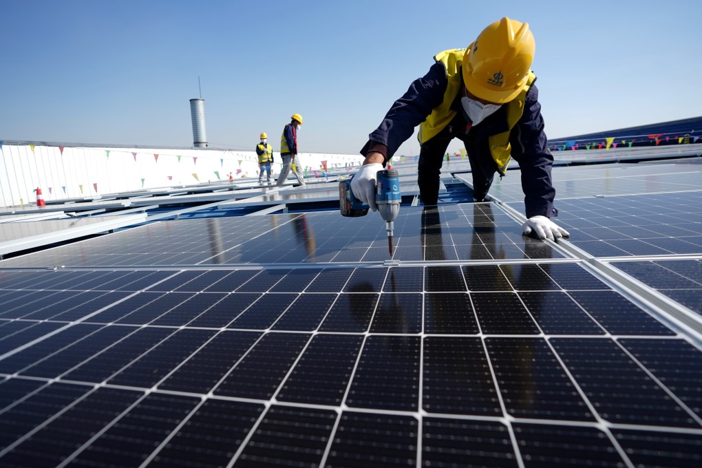 A worker installs photovoltaic power panels on the roof of a factory in Tangshan, in the northern Hebei province. Photo: Xinhua