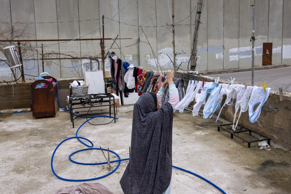 A woman hangs out laundry in Jeruslaem where atrocities are committed amid the longstanding Israeli-Palestinian conflict. Photo: AP