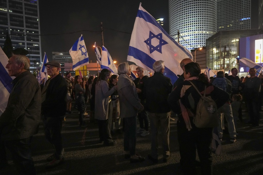 Israelis observe a moment of silence for victims of a shooting in Jerusalem, at the beginning of a protest against the plans by Prime Minister Benjamin Netanyahu’s new government to overhaul the judicial system, in Tel Aviv, Israel on Saturday. Photo: AP