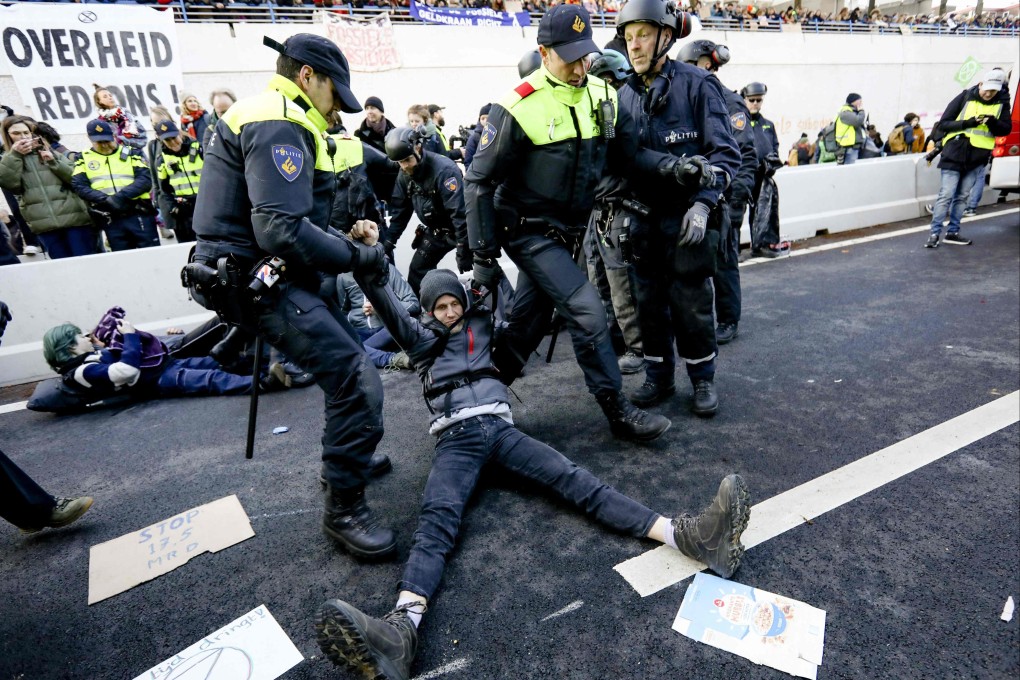 Police arrest Extinction Rebellion climate activists as they block the A12 motorway during a demonstration in The Hague on Saturday. Photo: ANP / AFP