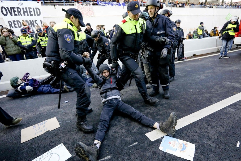 Police arrest Extinction Rebellion climate activists as they block the A12 motorway during a demonstration in The Hague on Saturday. Photo: ANP / AFP