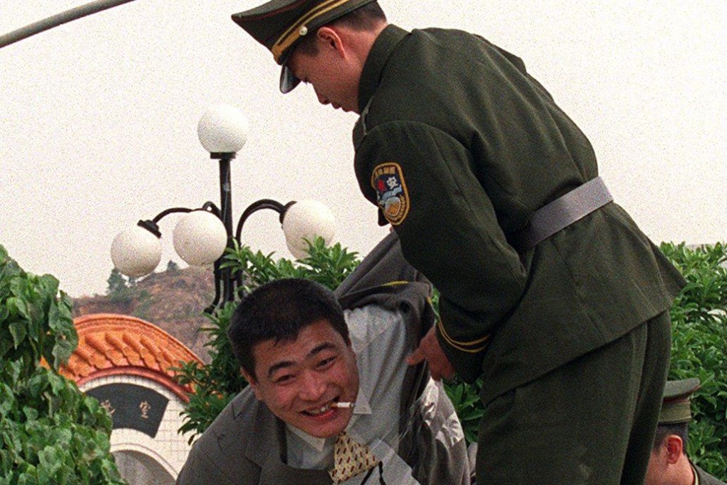 A policeman helps a Chinese pirate sentenced to death for murder board a truck for the execution grounds in Shanwei, China, after he and his fellow convicts had feasted with family and drunk rice wine. Thirteen pirates were executed for killing 23 sailors on a cargo ship in 1999. Photo: SCMP