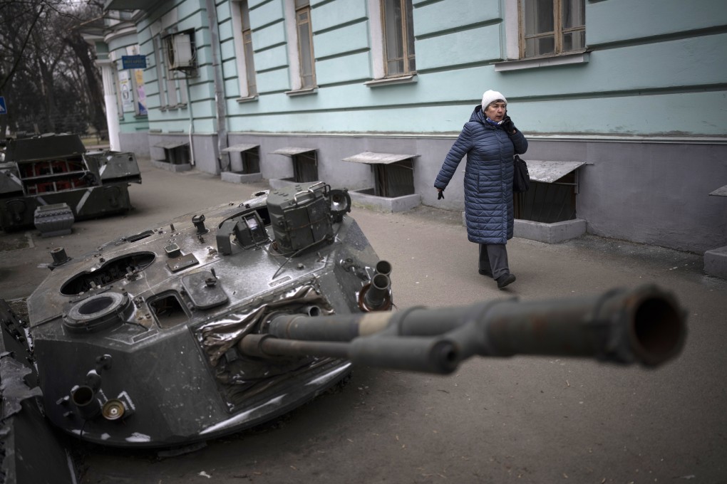 A woman walks by a destroyed Russian tank displayed on a Kyiv street on January 26. A Russian firm is now offering money to soldiers who destroy or capture foreign tanks. Photo: AP