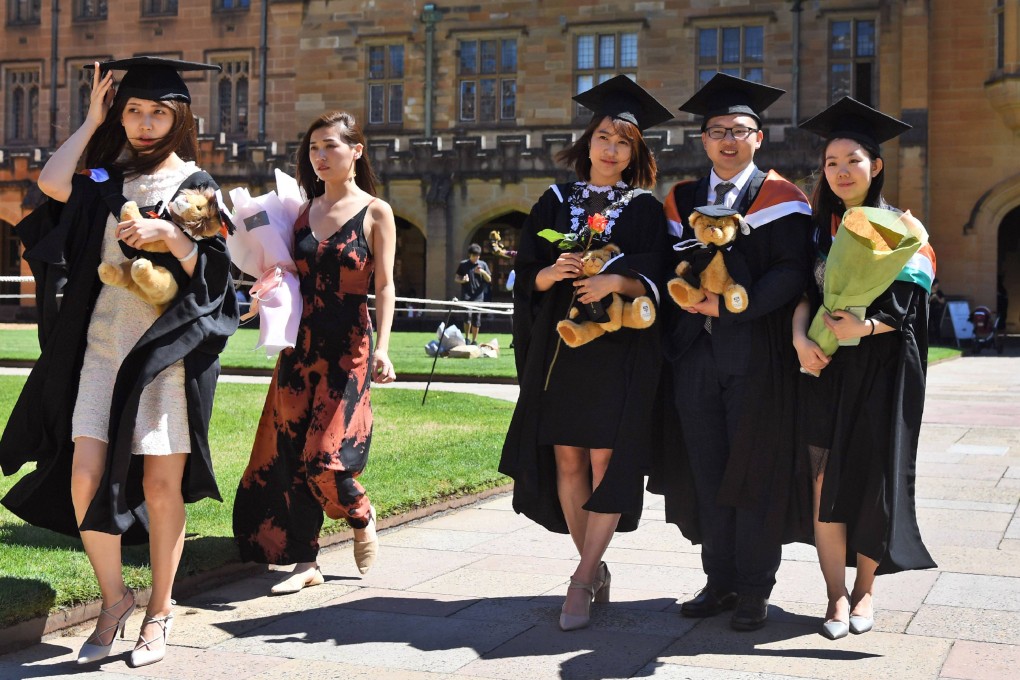Students from China pose for family photos after graduating from a course in commerce at Sydney University in 2017. Photo: AFP