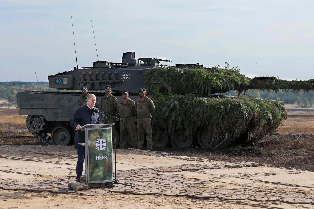 German Chancellor Olaf Scholz speaks next to a Leopard 2 battle tank of the German armed forces while visiting troops at a military ground in Ostenholz, northern Germany, on October 17, 2022. Germany on January 25 approved the delivery of Leopard 2 tanks to Ukraine, after weeks of pressure from Kyiv and many allies. Photo: AFP