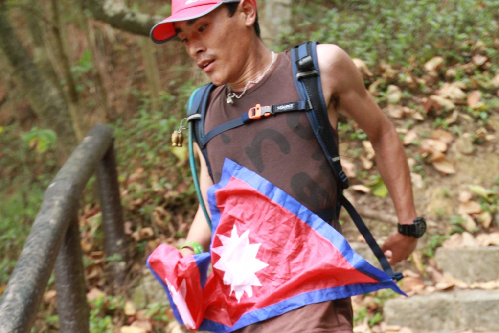 A runner displays the national flag of Nepal as he runs the Gurkha Trailblazer. Photo: Handout