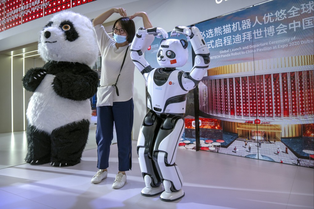 A visitor poses for a photo with a robotic panda at a display from Chinese robot maker UBTech at the World Robot Conference in Beijing in September 2021. Photo: AP