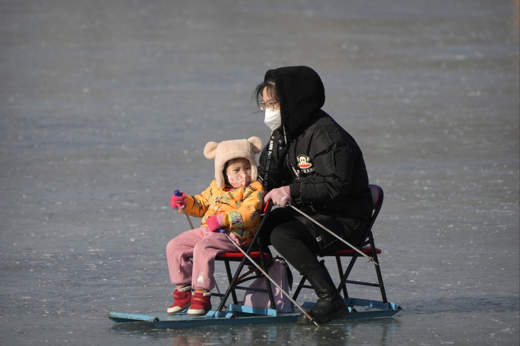 A woman and a child ride an ice chair on a frozen pond at a public park in Beijing, on January 17. China has announced its first population decline in decades as what has been the world’s most populous nation ages and its birth rate plunges. Photo: AP
