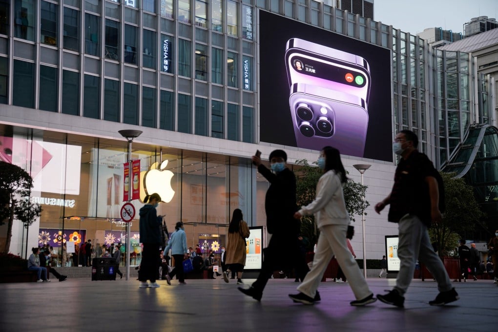 People walk near a display advertising Apple’s iPhone 14 outside its store in Shanghai on November 7, 2022. Photo: Reuters