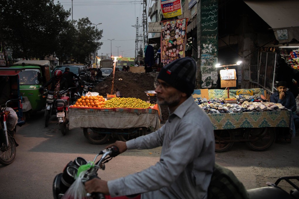 Vendors sell fruit under lights lit by batteries in Lahore, Pakistan, during a blackout on January 23. Photo: Bloomberg