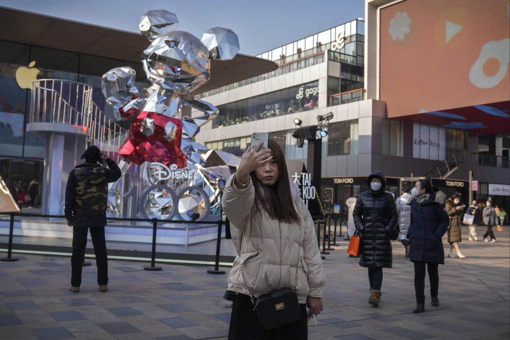 A woman takes a selfie at an outdoor shopping centre in Beijing on January 5. There is a risk the Covid-19 crisis has intensified the motivation to save. Photo: AP