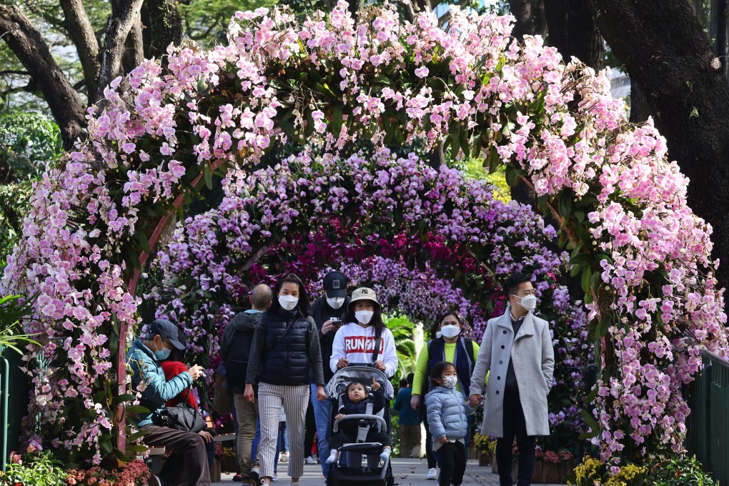 People wearing masks walk through a tunnel of orchids at the Hong Kong Zoological and Botanical Gardens in Central on January 28.  Photo: Dickson Lee