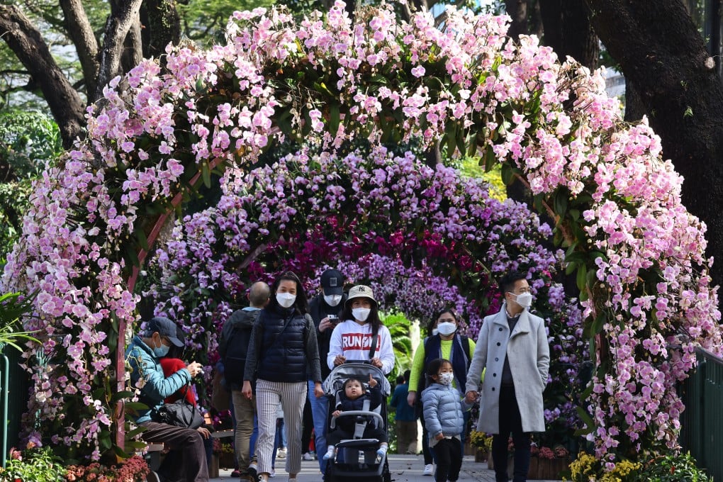 People wearing masks walk through a tunnel of orchids at the Hong Kong Zoological and Botanical Gardens in Central on January 28. Photo: Dickson Lee