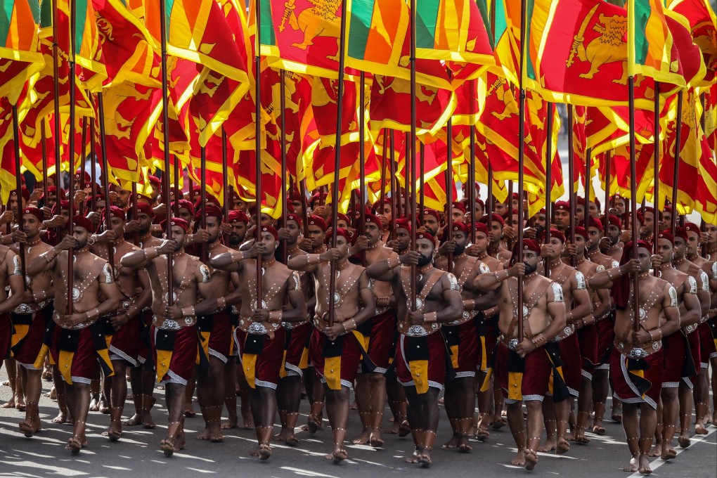 Sri Lankan soldiers, dressed in traditional costumes, march with national flags during the 75th Independence Day parade in Colombo. Photo: EPA-EFE
