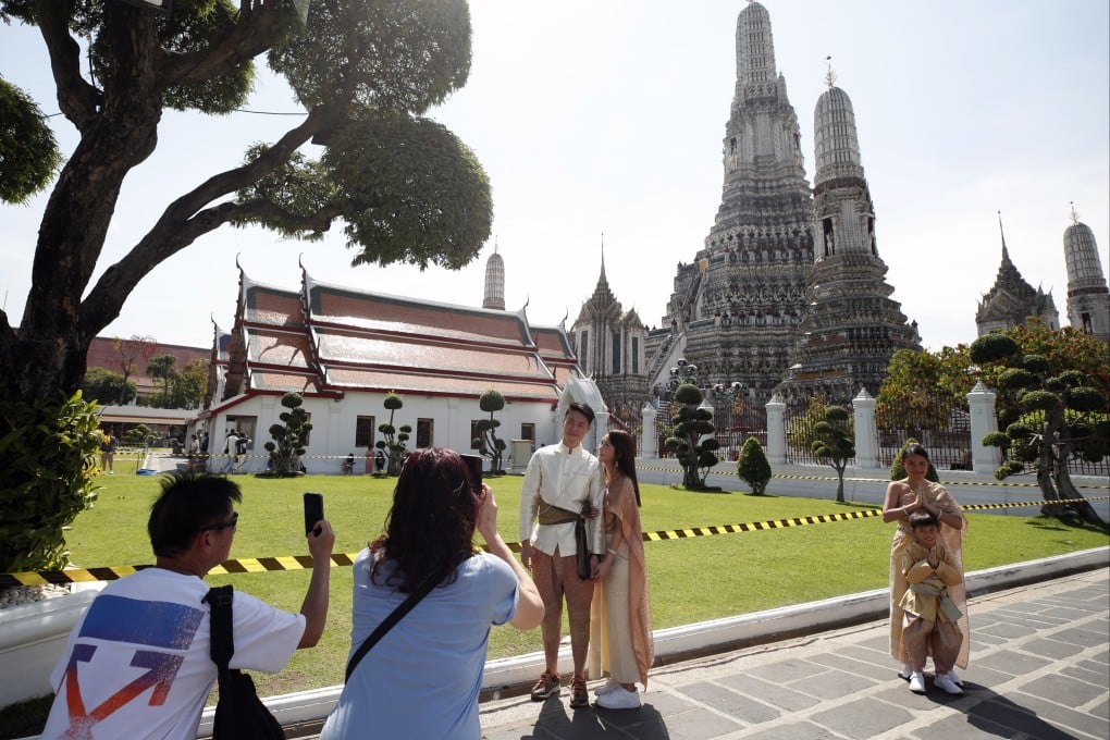 Chinese tourists, dressed in Thai traditional costumes from a clothing rental shop, visit the Temple of Dawn in Bangkok on January 23. The surge in Chinese tourists after the country’s reopening is creating welcome problems for Asian retailers and tourism industries as they scramble to accommodate the influx. Photo: EPA-EFE