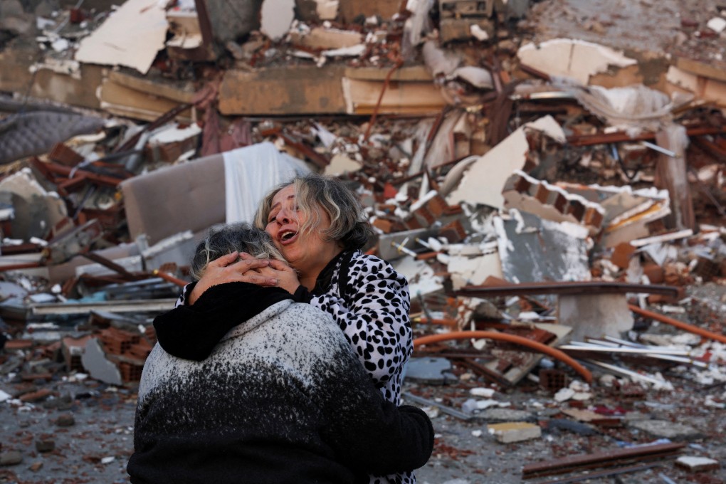 A woman embraces another person near rubble in Hatay, Turkey. Photo: Reuters