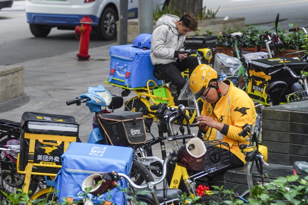 A Meituan Dianping delivery driver (front) and an Ele.me delivery driver (back) sit on standby in Shenzhen’s Futian district. The two delivery providers control a combined 95 per cent of the market, but rival ByteDance is looking to grab a slice of the market through its short video app Douyin. Photo: SCMP / Roy Issa