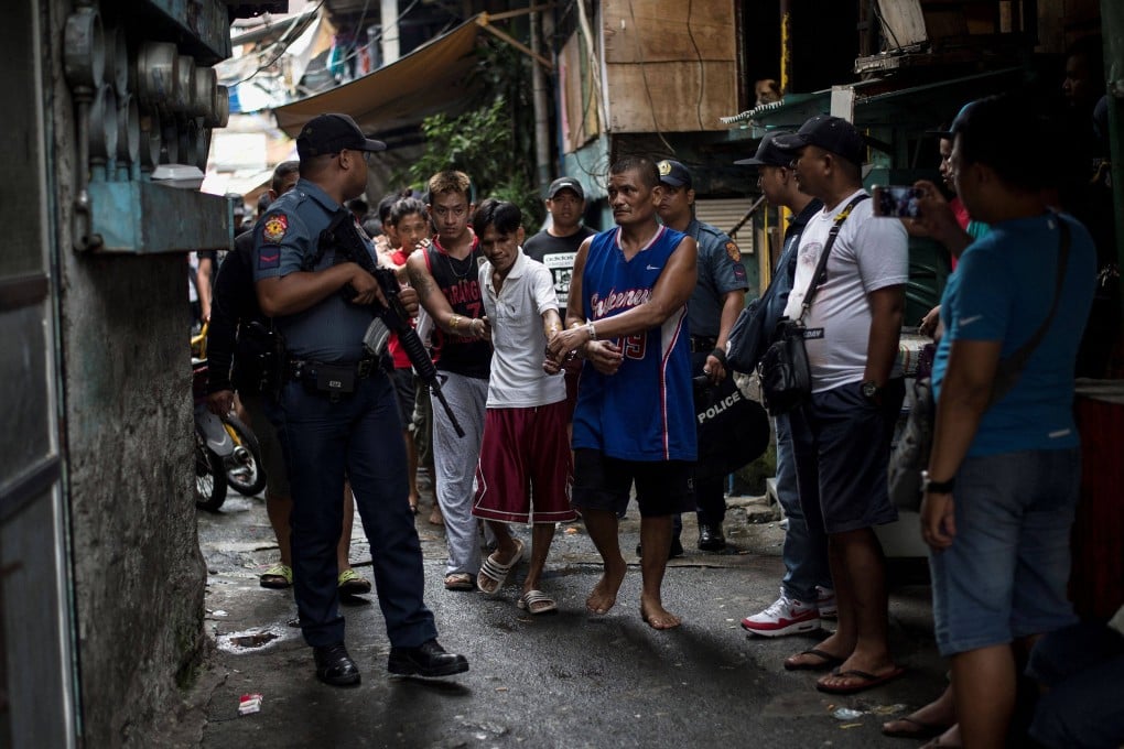 Men are rounded up after police officers conduct a large-scale anti-drug raid at a slum community in Manila on July 20, 2017. Photo: AFP