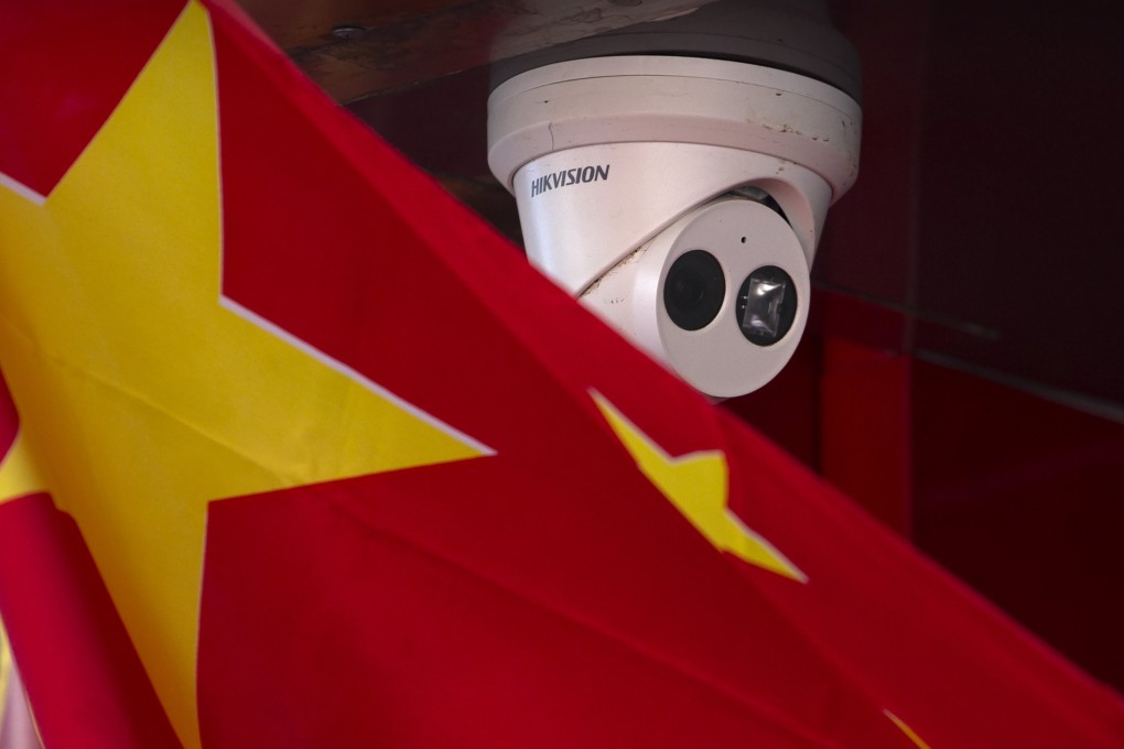 A Chinese flag hangs near a Hikvision security camera in Beijing. Australia’s national war memorial is removing cameras made by the company. Photo: AP