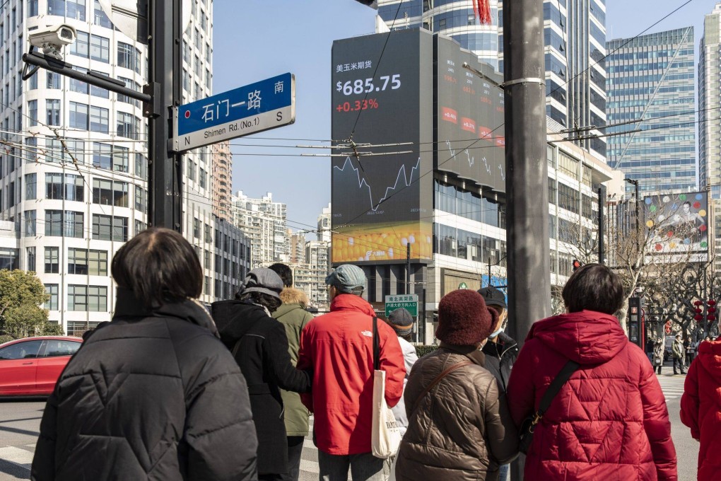 Pedestrians walk past a giant sceen showing financial data in Shanghai on January 30. Photo: Bloomberg