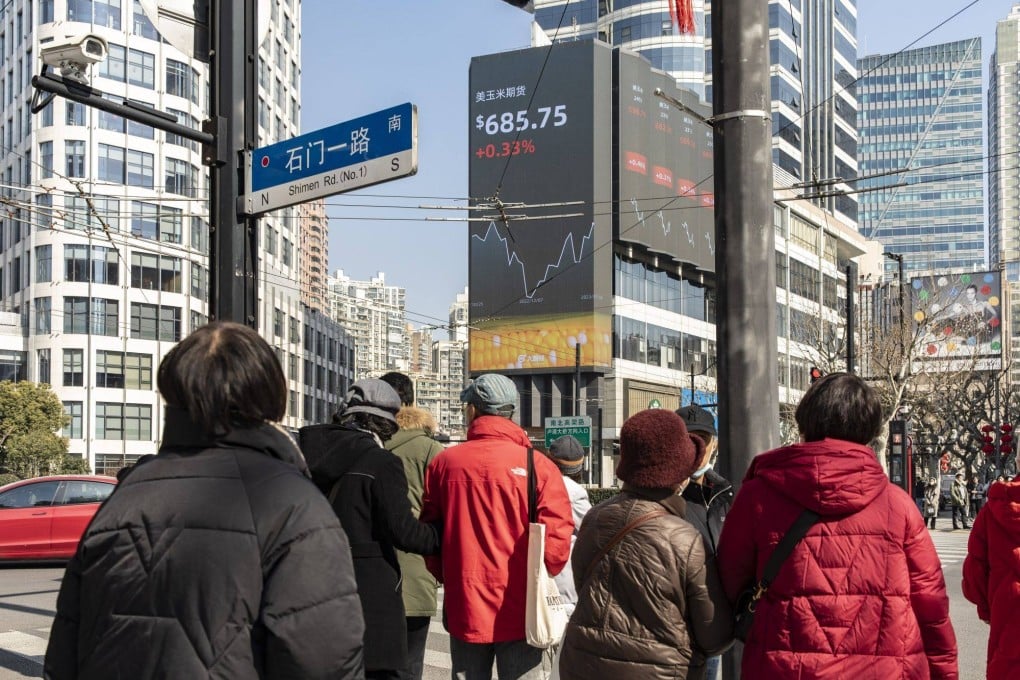 Pedestrians walk past a giant sceen showing financial data in Shanghai on January 30. Photo: Bloomberg