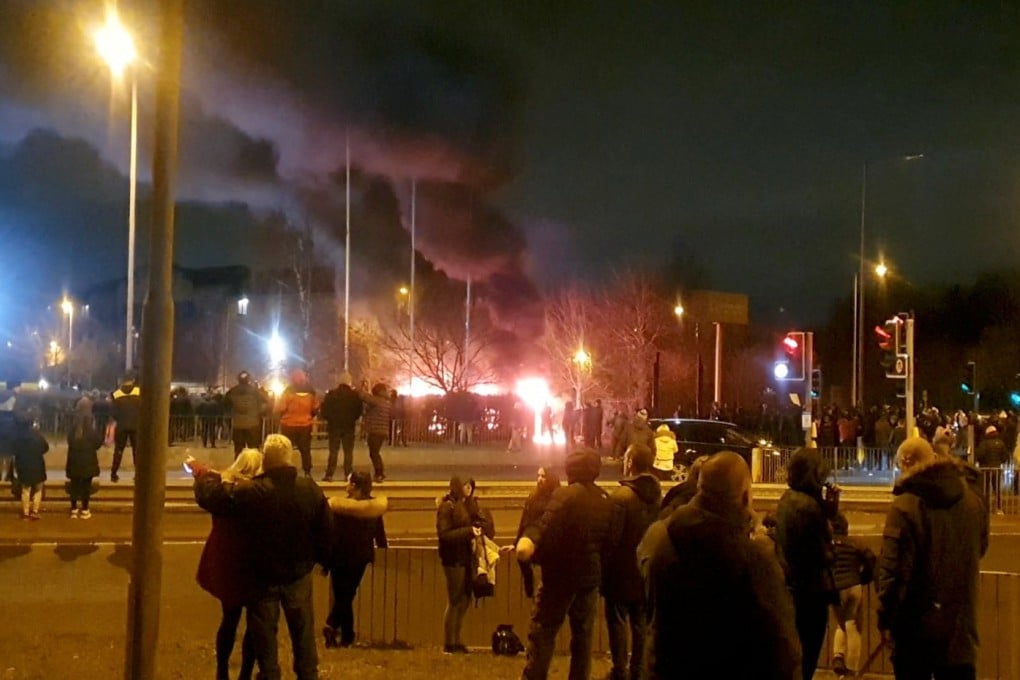 People look at a fire outside a hotel providing refuge to asylum seekers following a protest in Knowsley near Liverpool, UK on Saturday. Photo: Courtesy of Tony Broster via Reuters