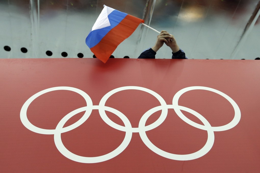 FILE - A Russian flag is held above the Olympic Rings at Adler Arena Skating Centre during the Winter Olympics in Sochi, Russia on February 18, 2014. Photo: AP