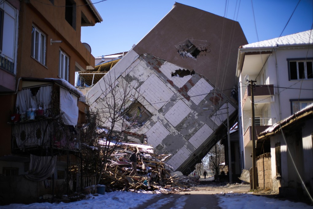 A man walks near a building that collapsed on a neighbouring house in Golbasi, Turkey on Monday. Photo: AP