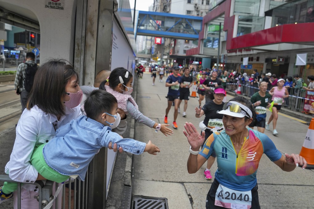 Supporters wearing masks greet runners during the Standard Chartered Hong Kong Marathon on Sunday. Photo: Elson Li