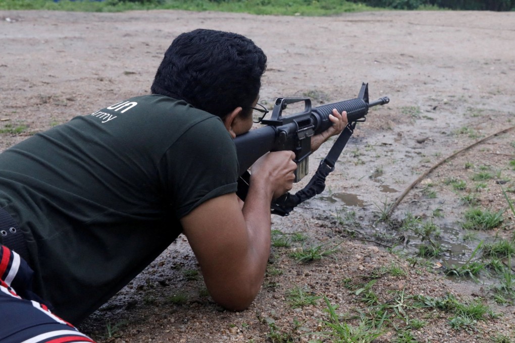 Sithu Maung, an elected member of parliament in the 2020 election, aims a gun at a training camp in an area controlled by ethnic Karen rebels, Karen State, Myanmar. Photo: Reuters/File