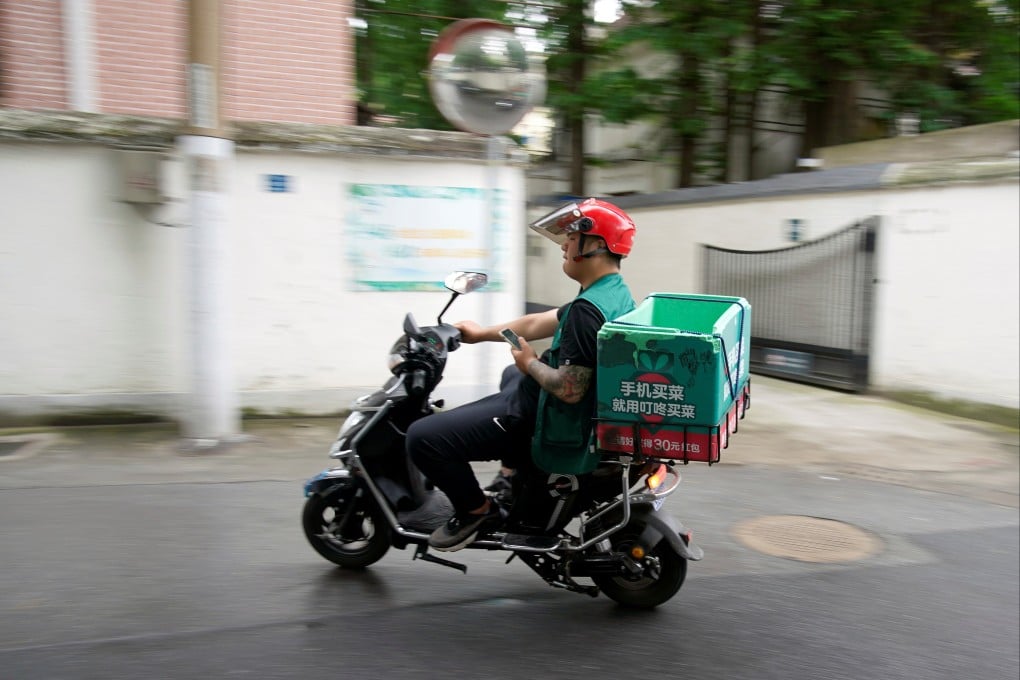A worker of Chinese online grocery delivery platform Dingdong Maicai seen on a street in Shanghai on June 10, 2021. Photo: Reuters