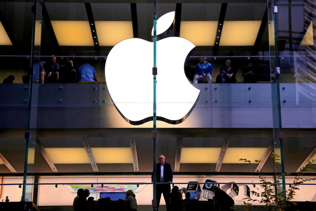 A customer stands underneath an illuminated Apple logo, as he looks out the window of the Apple Store located in central Sydney, Australia, on May 28, 2018. Photo: Reuters