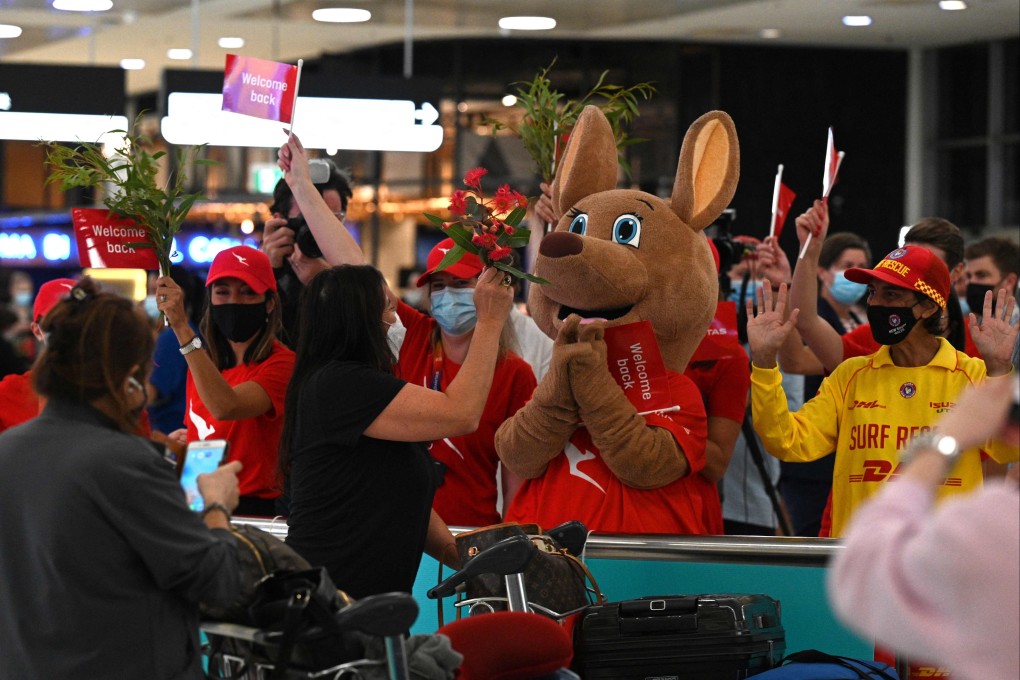 Staff offer flowers to passengers upon their arrival at the Sydney International Airport in February, 2022, as Australia reopened its borders for fully vaccinated visa holders, tourists, and business travellers. Photo: AFP