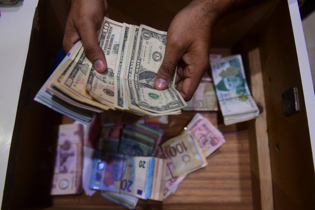 A dealer counts US dollars at a money exchange market in Karachi, Pakistan, on January 27. The US dollar enjoyed a bull run in 2022, but many of the underlying factors driving its surge are starting to abate. Photo: AFP