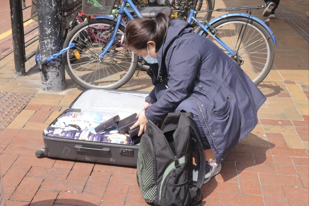 A woman stuffs her suitcase with goods at Sheung Shui, where parallel traders and couriers have gathered. Photo: Jelly Tse