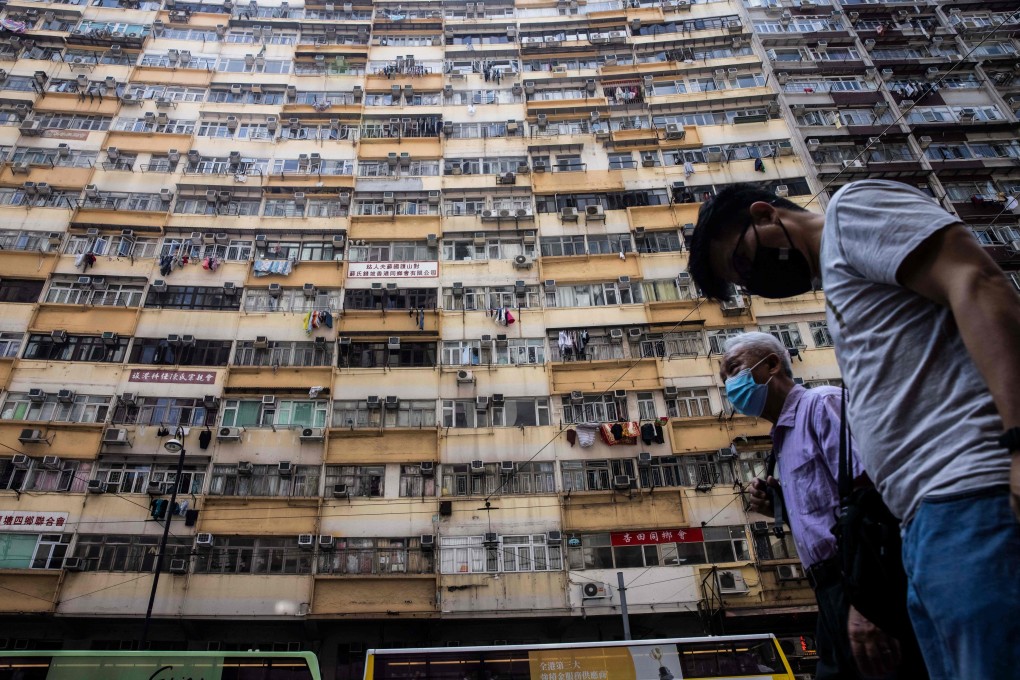 People walk past a residential apartment block in Hong Kong. Photo: AFP