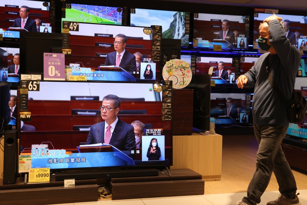 Hong Kong Financial Secretary Paul Chan Mo-po appears on a Quarry Bay store’s TV screens as he delivers the 2023-24 budget. Photo: May Tse